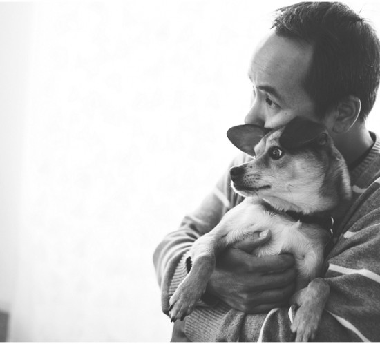 Los Angeles lifestyle photographer capturing a candid photograph of a man hugging a dog